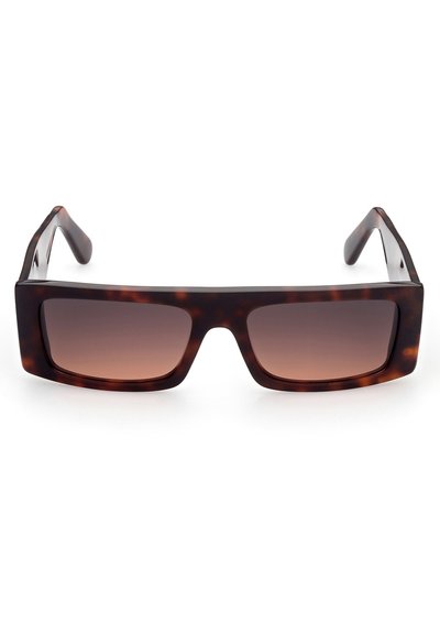 Occhiali da sole in tartaruga marrone con una montatura quadrata spessa e lenti sfumate, che presentano aste spesse e una superficie liscia.