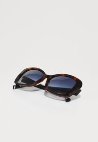 Ochelari de soare din tortoiseshell maro cu lentile rectangulare, nuanță de gradient albastru închis și brațe negre cu un detaliu subtil în dungi.