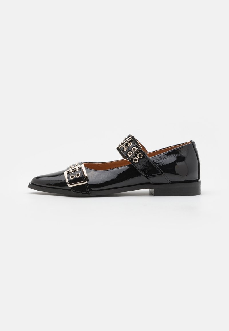 Chaussure Mary Jane en cuir verni noir avec un bout pointu, dotée de deux boucles métalliques sur la sangle et d'un petit talon carré.