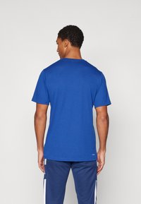 Blue crew-neck t-shirt made of breathable fabric with short sleeves. The back view shows a smooth texture and a relaxed fit.