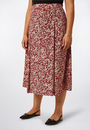 Rode midi-rok met bloemenprint en witte bladpatronen, geplooid ontwerp, zachte stof, gedragen met zwarte puntige platte schoenen. De rok valt net onder de knie.