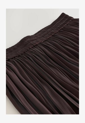 Jupe plissée en bordeaux profond, dotée d'une taille smockée et de plis verticaux, créant une texture fluide avec un fini brillant.