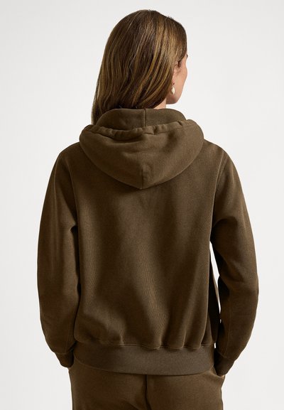 Brun bomullshettegenser med romslig hette, ribbestrikkede mansjetter og kant. Har en teksturert finish, vist bakfra med en jevn, uformell passform.