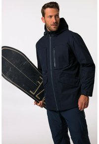 Navy sininen vedenpitävä takki, jossa on huppu, vetoketjullinen etuosa, kaksi paikkataskua ja säädettävät hihansuut, yhdistetty mustaan lumilauteen.