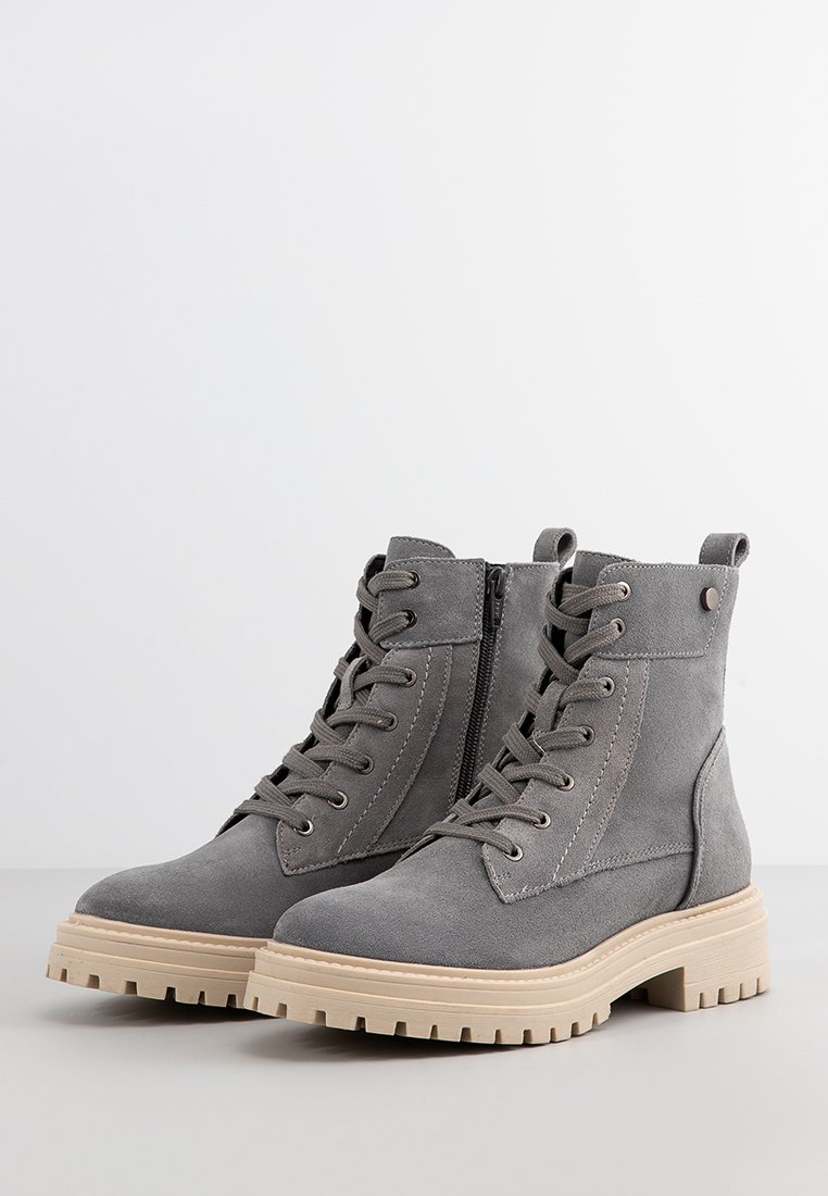 Graue Wildleder-Ankle Boots mit einer Schnürung an der Vorderseite, einem seitlichen Reißverschluss und einer klobigen beige Gummisohle. Verfügt über Nähte und kleine Akzentbeschläge.