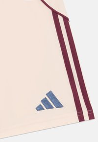 Helles rosa Sportoberteil mit maroonfarbigen Streifen und blauem gesticktem Logo. Glatter Stoff mit taillierter Passform und rundem Ausschnitt.