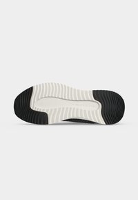 Semelle de chaussure avec motif en caoutchouc noir et blanc offrant une adhérence texturée et un logo "Marc O'Polo" au centre.