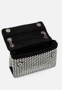 Borsa in suede nero con design borchiato e dettagli argentati, chiusura a magnete e interno aperto per lo stoccaggio.