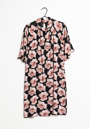 Robe noire à manches courtes avec un grand motif floral rose doux et un détail de col noué, suspendue sur un cintre noir sur fond blanc.