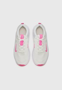 White athletic shoes with pink accents, featuring a mesh upper, round toe, flat laces, and a cushioned sole. Notable logo on the side.
