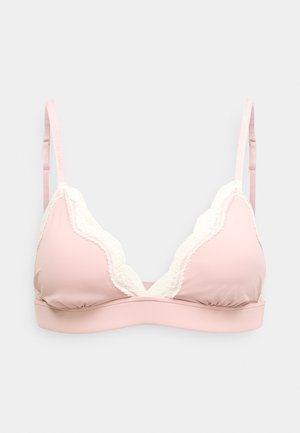 Hele-roosa traadita rinnahoidja valge pitsiga kaarjatel ja reguleeritavate õlapaeltega valgel taustal.