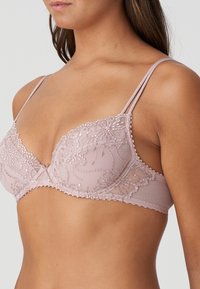 Lichtroze kanten bralette met bloemenborduursel, gegolfde randen en verstelbare dunne bandjes. Zacht, doorschijnend materiaal met een draadontwerp.
