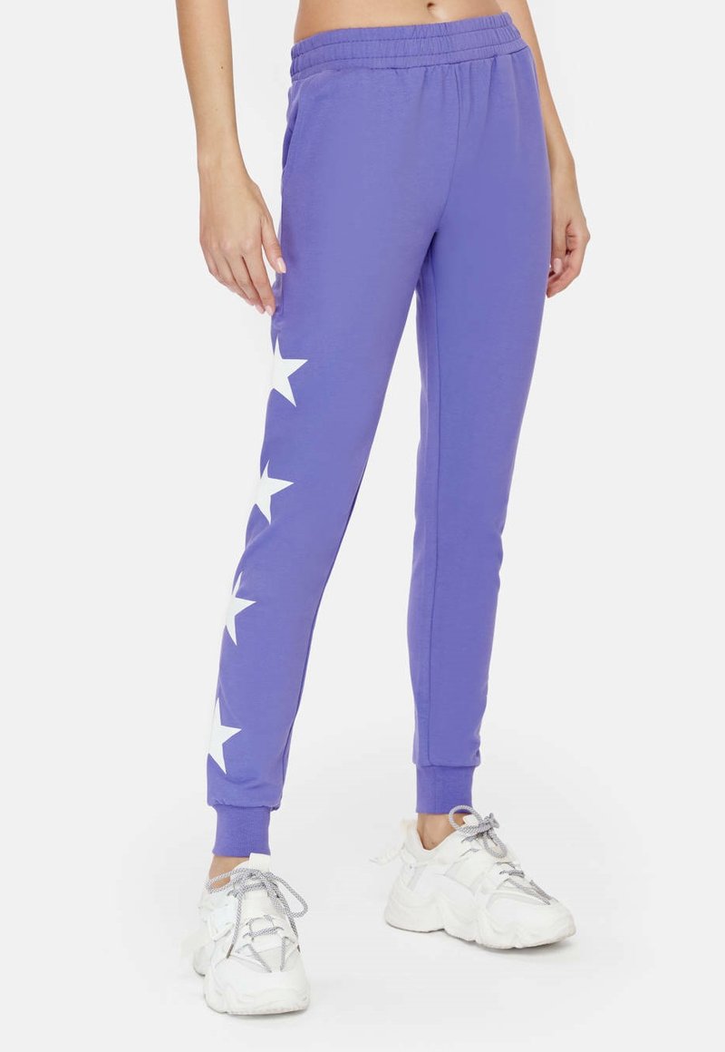 Paarse sweatpants met een tapered fit, met witte sterpatronen aan de buitenzijde en een elastische tailleband voor comfort.
