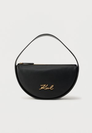 Geantă neagră semicirculară cu fermoar în partea de sus și logo auriu "Karl" pe față, prevăzută cu o mânere neagră asortată.