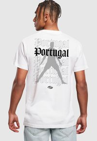 Hvid bomulds T-shirt med et dristigt sort "Portugal" design og en grå silhuetfigur. Året "2024" trykt under den primære grafik.