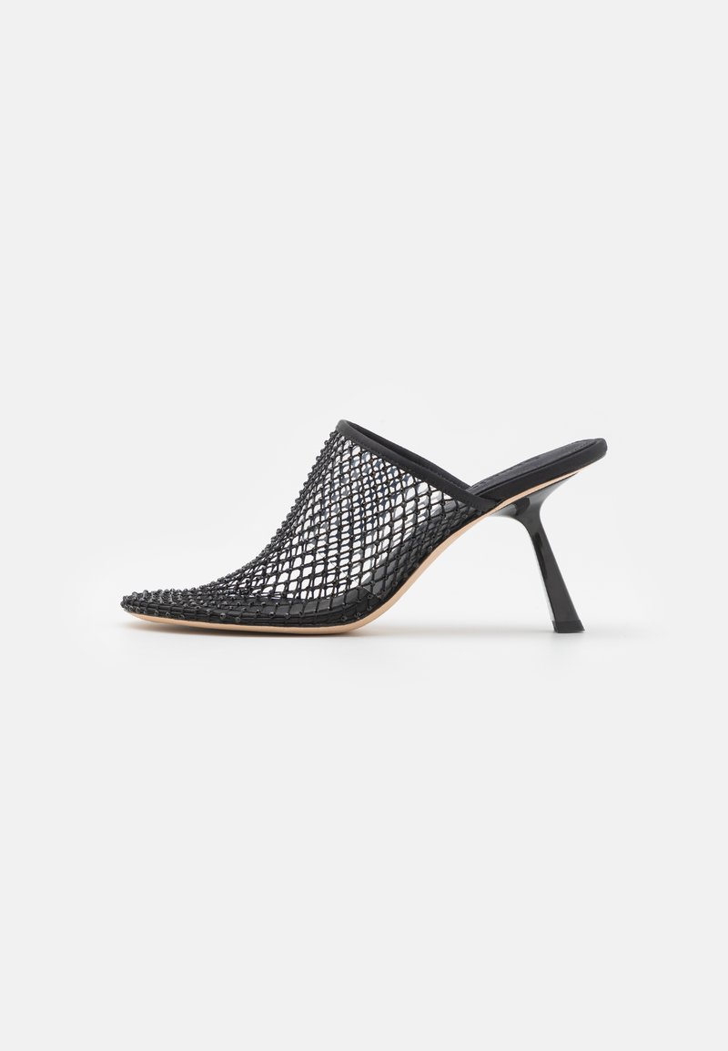 Černé síťované muly s špičatou špičkou, otevřenou zadní částí a štíhlým vysokým podpatkem. Mají texturovaný tkaný design po celé svrchní části.