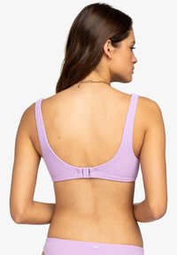 Lila bikini bovenstuk met een gestructureerde stof, brede bandjes en een lage ronde rug. Voorzien van een haaksluiting aan de achterkant voor een veilige pasvorm.
