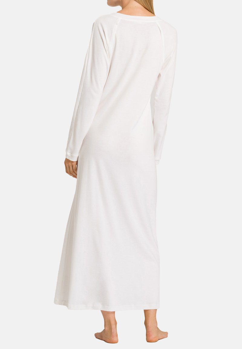 Lunga camicia da notte bianca con maniche lunghe, caratterizzata da un colletto rotondo e una vestibilità ampia che scende fino alle caviglie, realizzata in tessuto morbido e liscio.