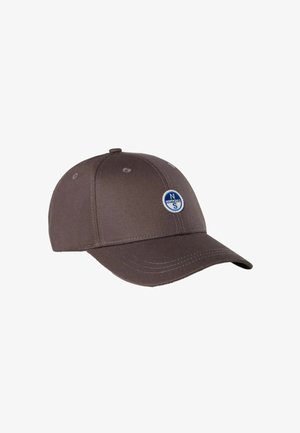 Cappellino da baseball marrone con corona arrotondata e visiera curva. Presenta un logo circolare blu e bianco sulla parte anteriore, con dettagli cuciti lungo i bordi.