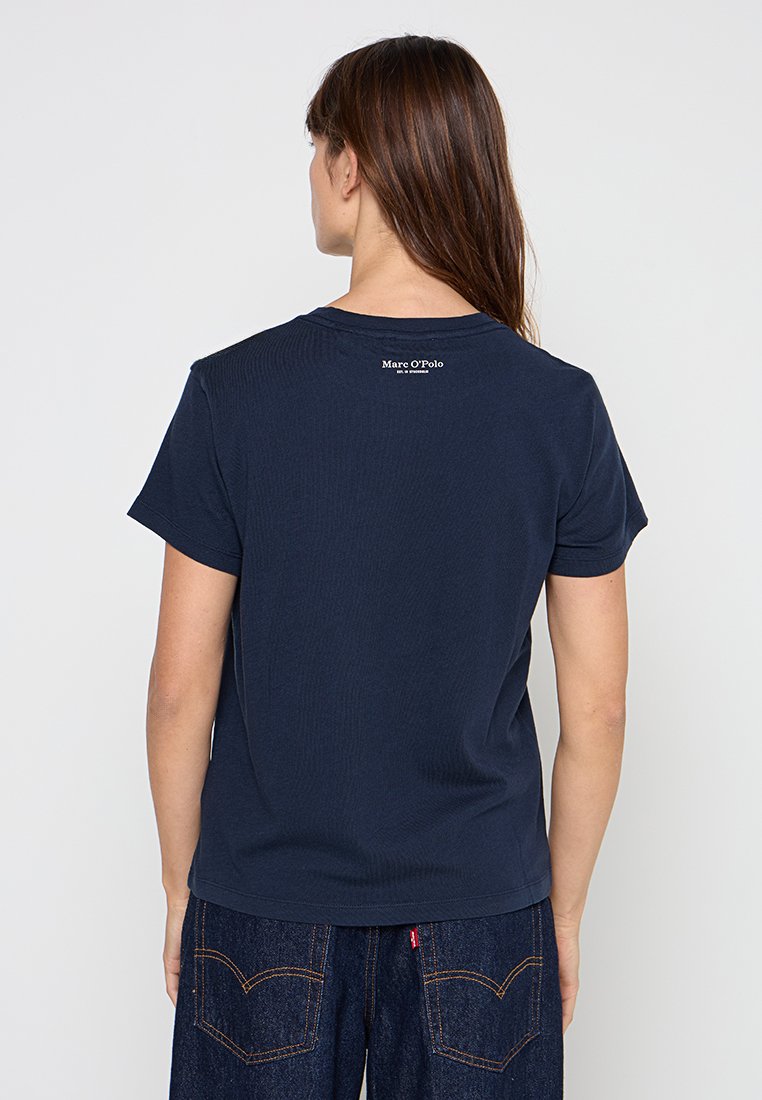 Kurzes, marineblaues T-Shirt aus Baumwolle mit geripptem Textur und einem kleinen weißen Logo auf dem oberen Rücken.