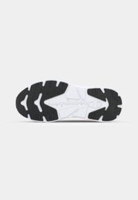 Rubber sneaker outsole with a black and white color scheme, featuring a textured tread pattern and logo imprint. Shape is athletic and contoured.