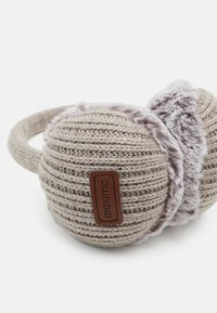 Strikkede øreklokker i lys beige med myk faux pelsfôr. Har en lærmerke med "maximo" merkevare. Rund form og justerbart hodebånd.
