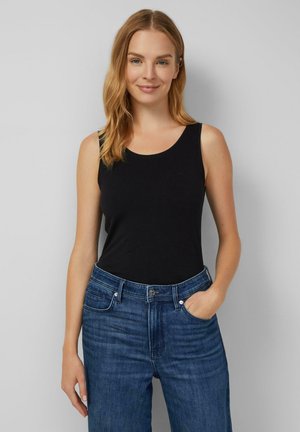 Black sleeveless top made of soft fabric, paired with blue denim jeans featuring a classic fit and five-pocket design.