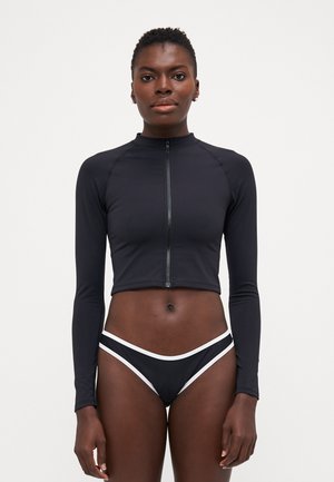 Black cropped long-sleeve top with a front zipper and high neckline, paired with black bikini bottoms featuring white accents. Smooth texture.