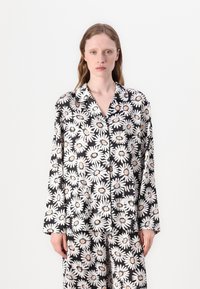 Set di pigiama nero con motivo a margherite in bianco e rosa. La parte superiore ha un colletto e maniche lunghe, con i pantaloni abbinati visibili.