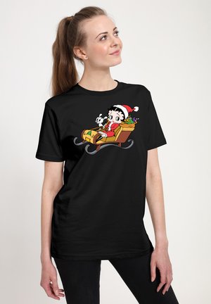 Sort T-shirt med et farverigt tegneserie-design af en figur i en kane med gaver, siddende ved siden af en kanin, iført en festlig julemandshat.