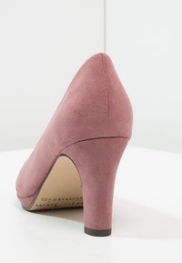 Mauve Wildleder Damen-Hochschuh mit abgerundetem Absatz und spitzem Zeh, fotografiert vor einem schlichten weißen Hintergrund.