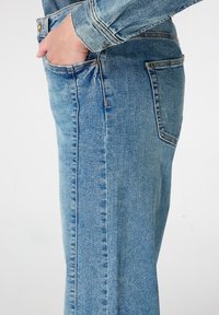 Lichtblauwe denim rok met een rechte snit, zijzakdetail, zichtbare stiksels en een gestructureerde stof.