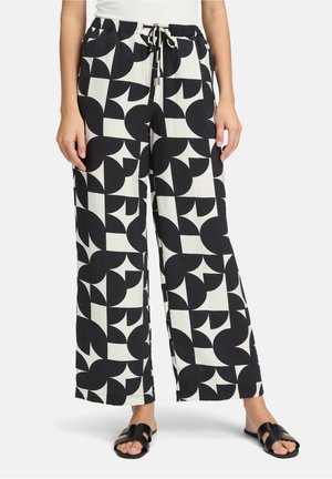 Zwart-wit geweven wijde broek met een koordsluiting in de taille, voorzien van cirkel- en geometrische patronen op een gestructureerde stof.