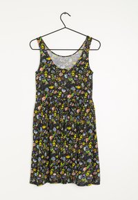 Vestido negro con flores y escote redondo, con vibrantes flores multicolores y falda recogida. Hecho de tela ligera, colgado en un gancho.