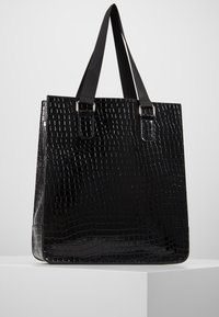 Sac cabas noir avec texture embossée effet crocodile brillante, forme carrée et deux anses noires avec accents métalliques argentés.