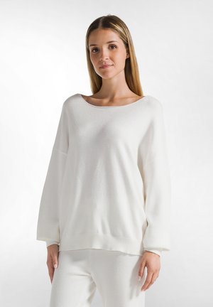 Weißer, übergroßer Pullover mit weitem Boots-Ausschnitt und gerippten Bündchen. Weiche Textur mit lässigem Schnitt, kombiniert mit passenden Hosen.