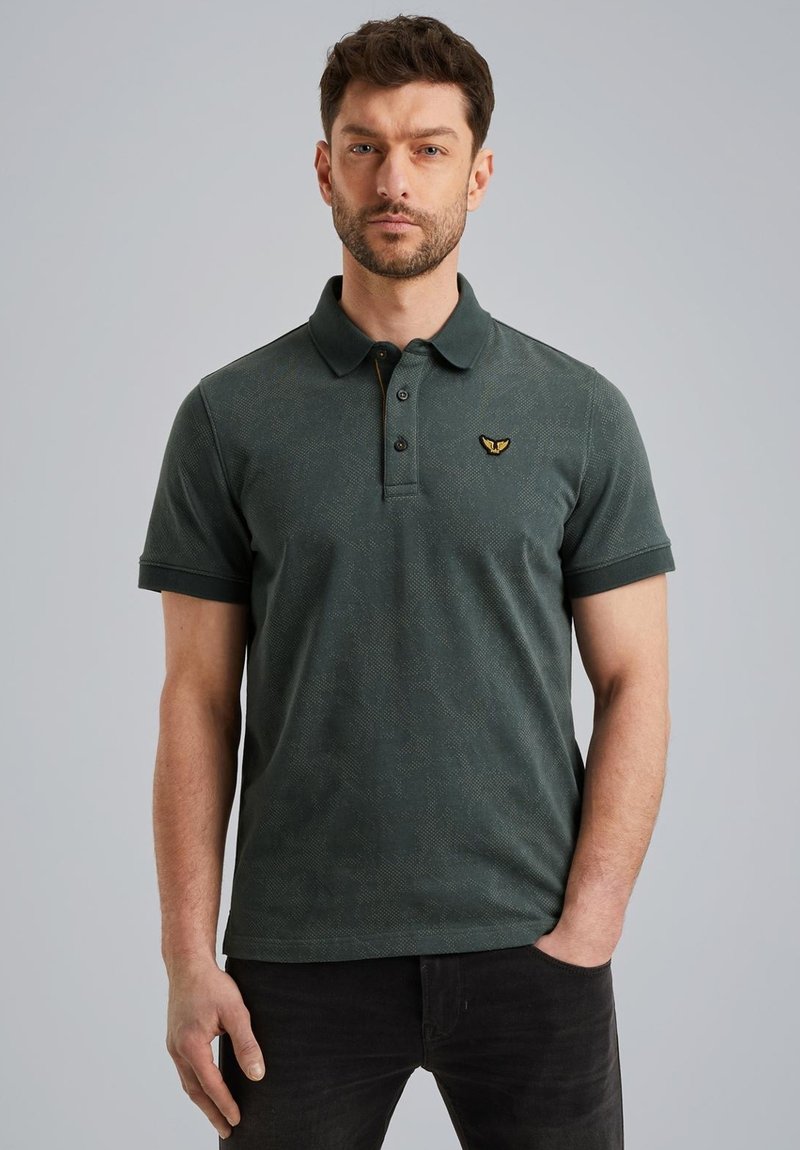 Mørkegrøn polo-shirt med et struktureret mønster, to-knaps knaplukning og et broderet logo på brystet. Korte ærmer og kravedesign.