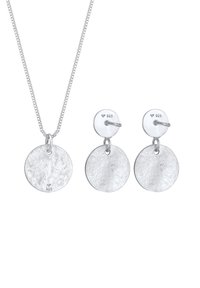 Set di collana e orecchini in argento. Presenta pendenti circolari con superficie testurizzata, contrassegnata 925, su una catena delicata e chiusura a perno.