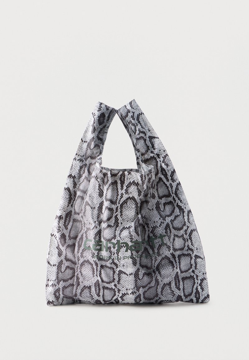 Sac de shopping réutilisable avec motif en peau de serpent noir et blanc et logo "Carhartt" vert sur le devant, posé sur un fond clair uni.