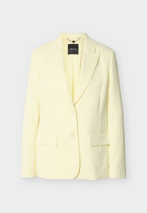 Blazer da donna giallo chiaro con rever a lancia, due tasche con patta frontali e chiusura con due bottoni, esposto su sfondo bianco.