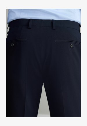 Marineblaue Hosen mit glatter Textur, ausgestattet mit zwei Gesäßtaschen mit Paspelierungen und einem Knopfverschluss, maßgeschneidert für eine figurbetonte Passform.