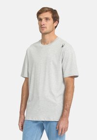 Lichtgrijs katoenen t-shirt met een ronde hals en korte mouwen, met een klein zwart spinnenlogo op de linkerschouder.