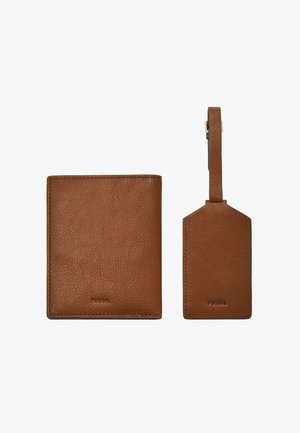 Ensemble porte-monnaie en cuir marron et étiquette de bagages. Le porte-monnaie présente une finition texturée avec des bords cousus ; l'étiquette de bagages a une forme plate et une sangle attachée.