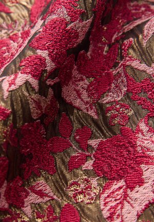 Raudona ir rožinė gėlių siuvinėjimas ant tekstūruotos juodos medžiagos, išskirtinai sudėtingi raštai su metaliniais akcentais. Sodrios spalvos ir sluoksniuota kompozicija.