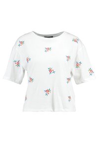 Camiseta de algodón blanca con mangas cortas y cuello redondo, que presenta bordados florales coloridos dispersos por toda la tela.