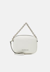 Biała prostokątna torebka Calvin Klein Jeans z srebrnym łańcuchem i odpinanym paskiem na ramię na jednolitym tle.