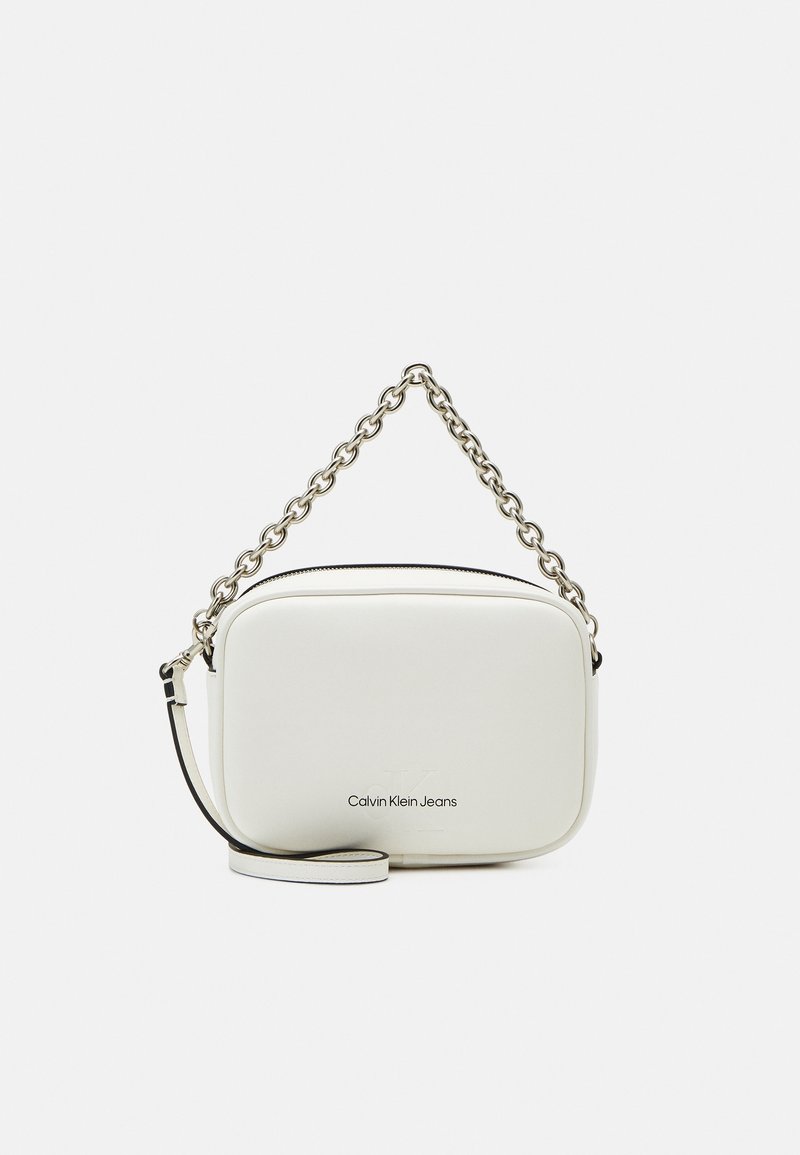 Biała prostokątna torebka Calvin Klein Jeans z srebrnym łańcuchem i odpinanym paskiem na ramię na jednolitym tle.