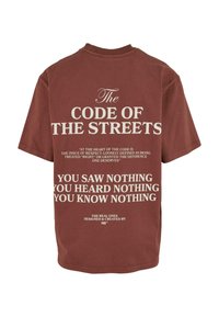 Camiseta de algodón burdeos con texto en blanco. En el frente se muestra la frase "El Código de las Calles" con citas adicionales debajo en letra grande.