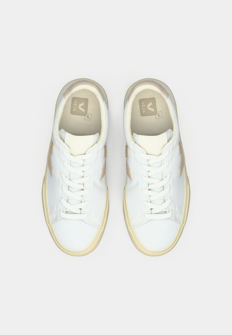 Sneakers bianche con accenti beige chiaro, caratterizzate da un design classico con tomaia bassa, punta tonda e chiusura anteriore con lacci. Realizzate in materiali sintetici.