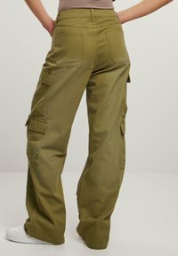 Olivgrüne Cargo-Hosen mit weitem Bein, aus strapazierfähigem Stoff. Verfügt über mehrere Seitentaschen und Gesäßtaschen. Minimalistisches Design.